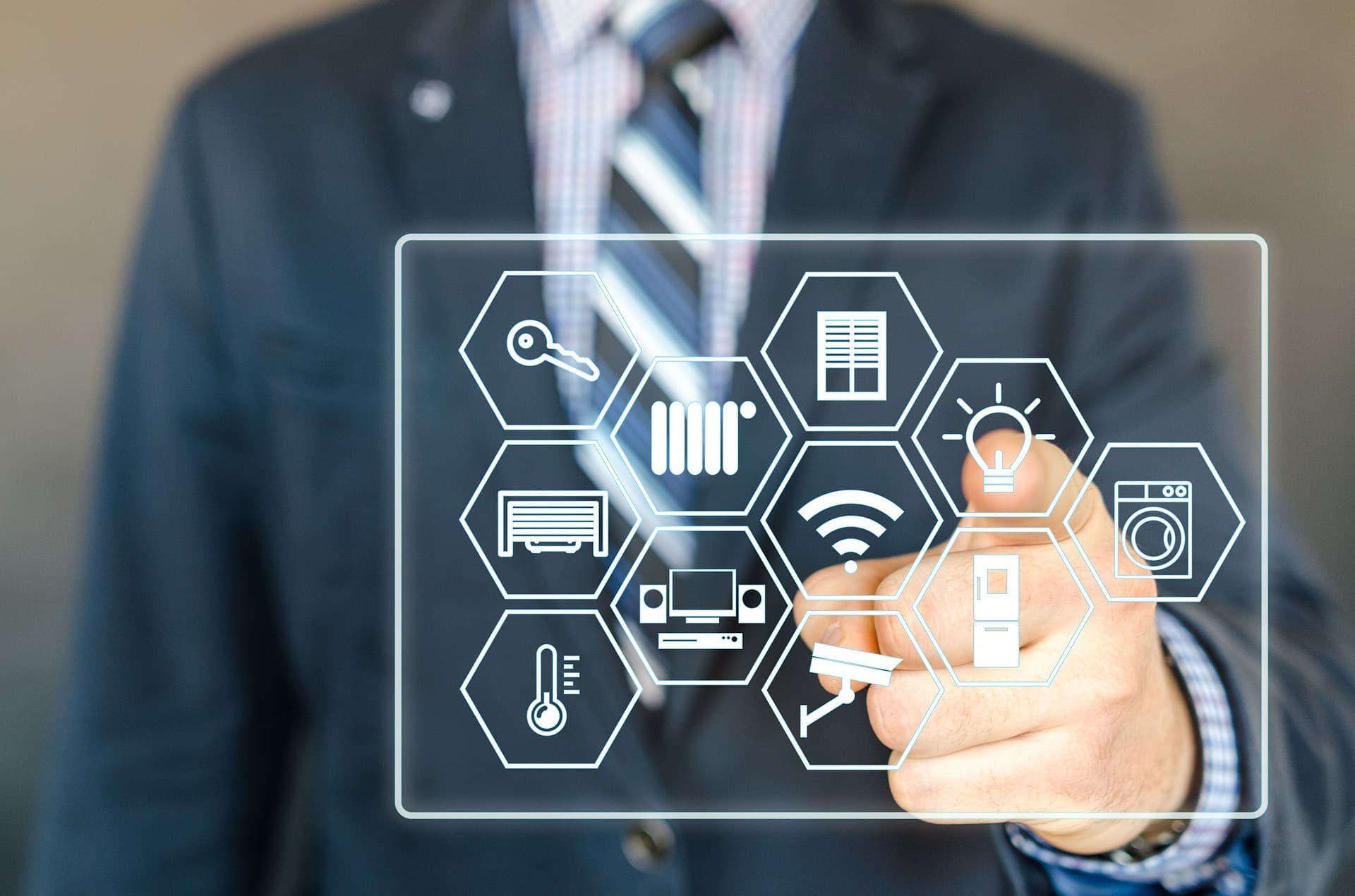 A person in a suit touching a transparent panel of connected smart-home icons